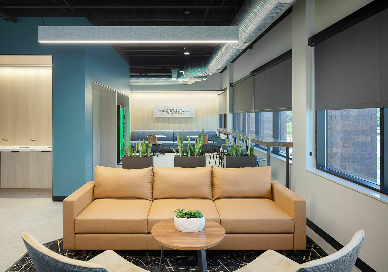 Watco seating area off of breakroom. Banquette seating and cafe tables, as well as counter seating and stools along window line. Caramel leather couch.