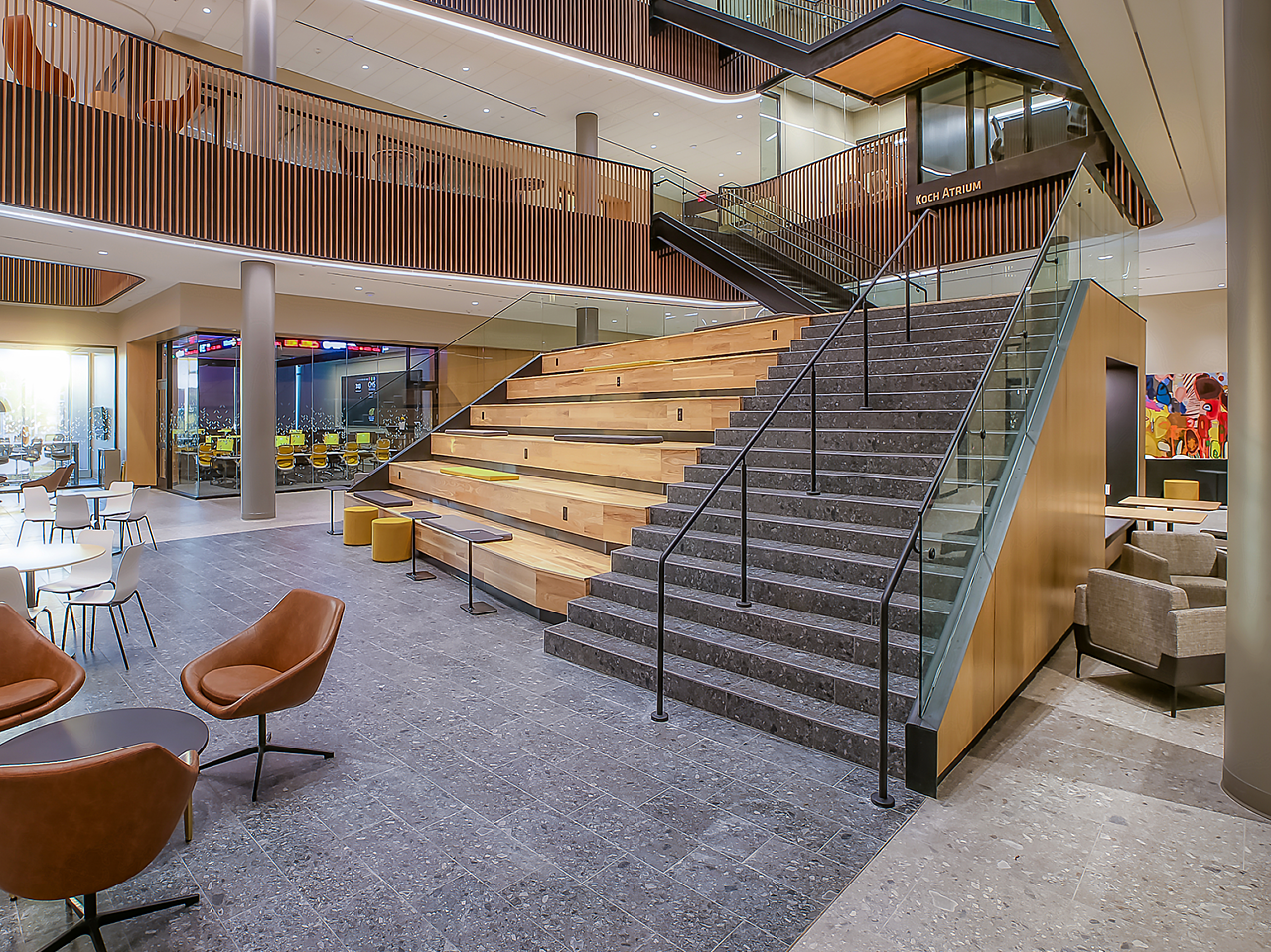 WSU Woolsey Hall-Stairway with built-in benched seating and computer tables. A variety of lounge and cafe seating areas for students surround stairway.