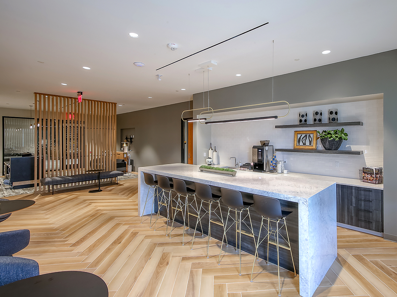 WSU Woolsey Hall-Breakroom with marble waterfall table and black stools.  Blue upholstered chairs and black cafe tables also fill the space.