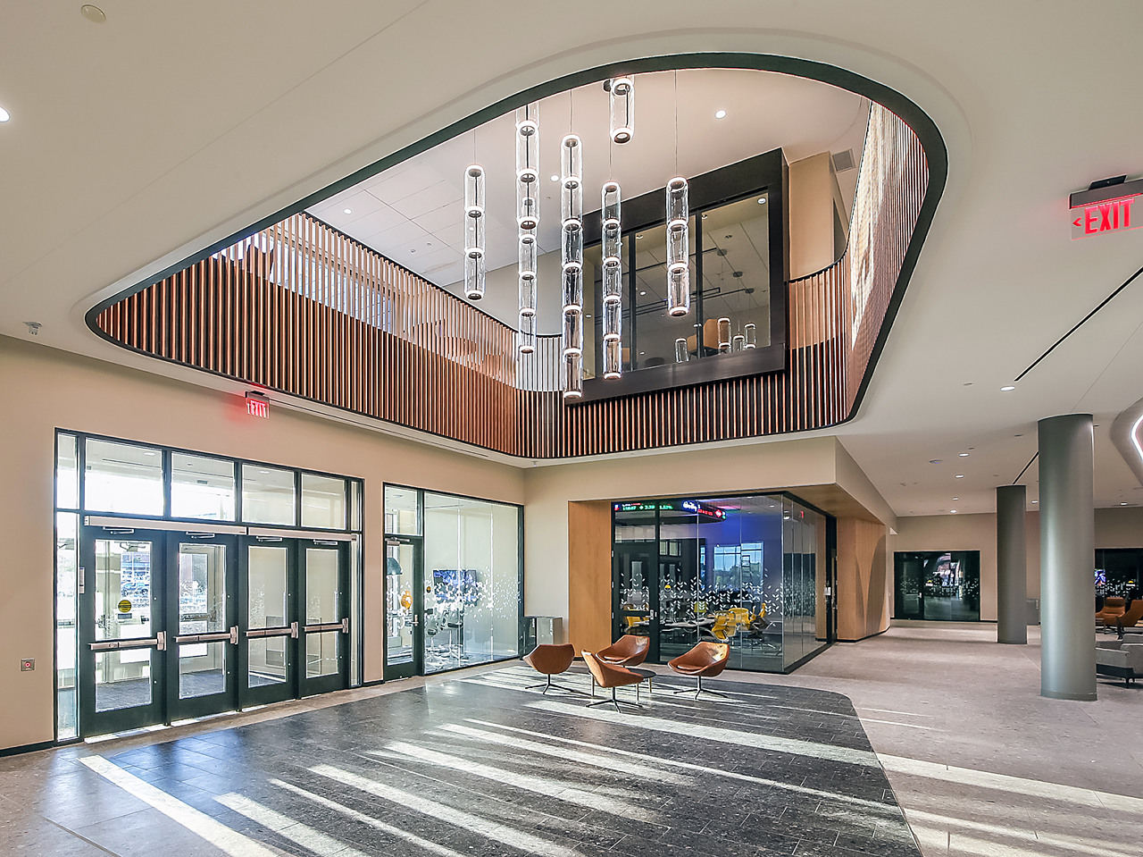 WSU Woolsey Hall-Entrance/Lobby area with glass chandelier lights over a grouping of brown leather lounge chairs. Classroom/conference areas in background