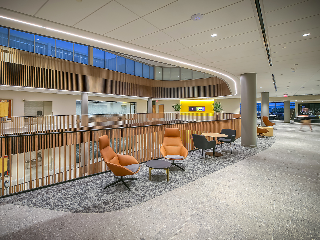 WSU's Woolsey Hall-An upper seating area with cafe tables and soft seating, along with brown leather high-back lounge chairs with coffee table.