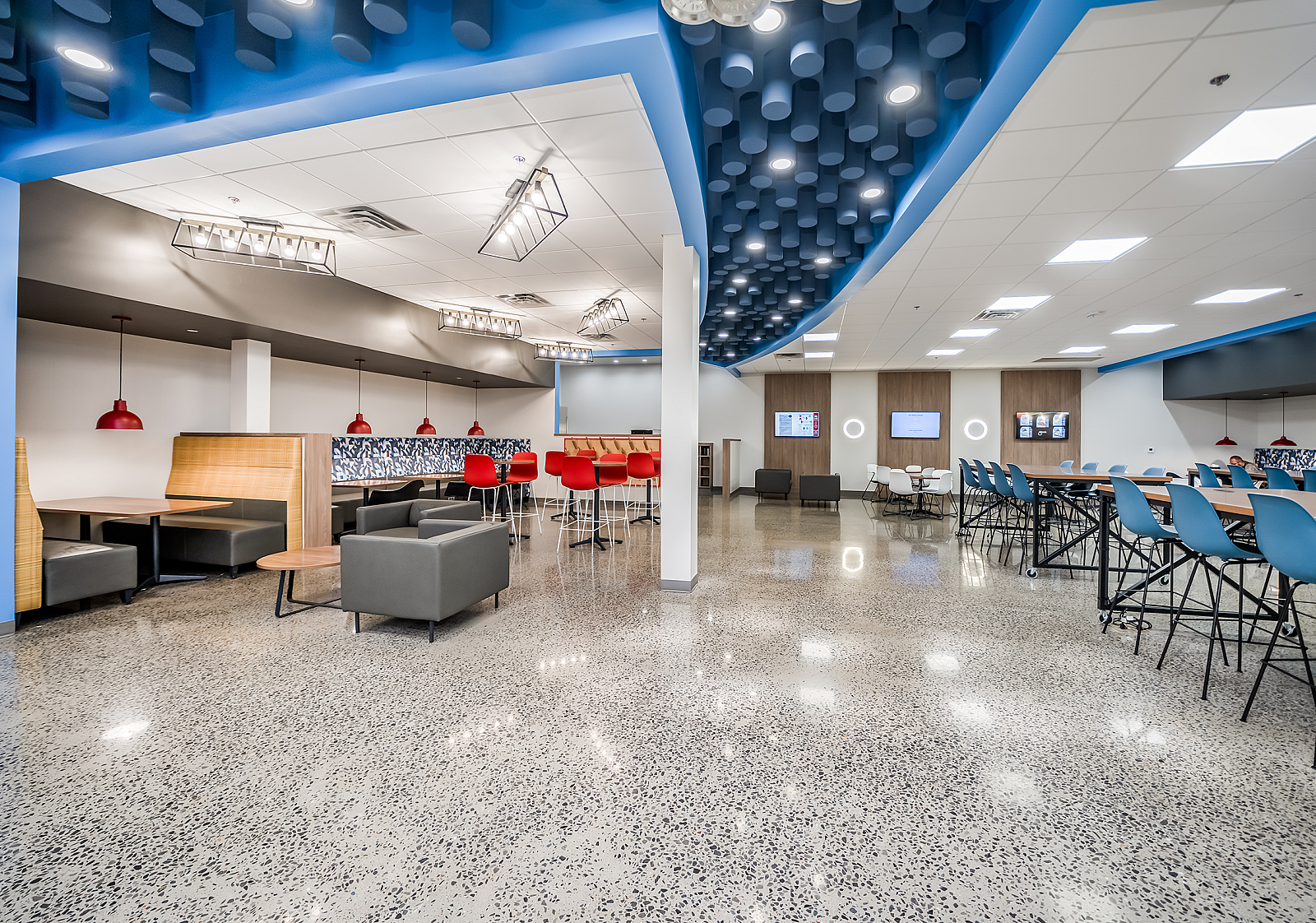 Wide view of Schwan's Co. employee breakroom with cafe, high-top, booth, banquette and bench seating options. Blue feature ceiling with built in lights