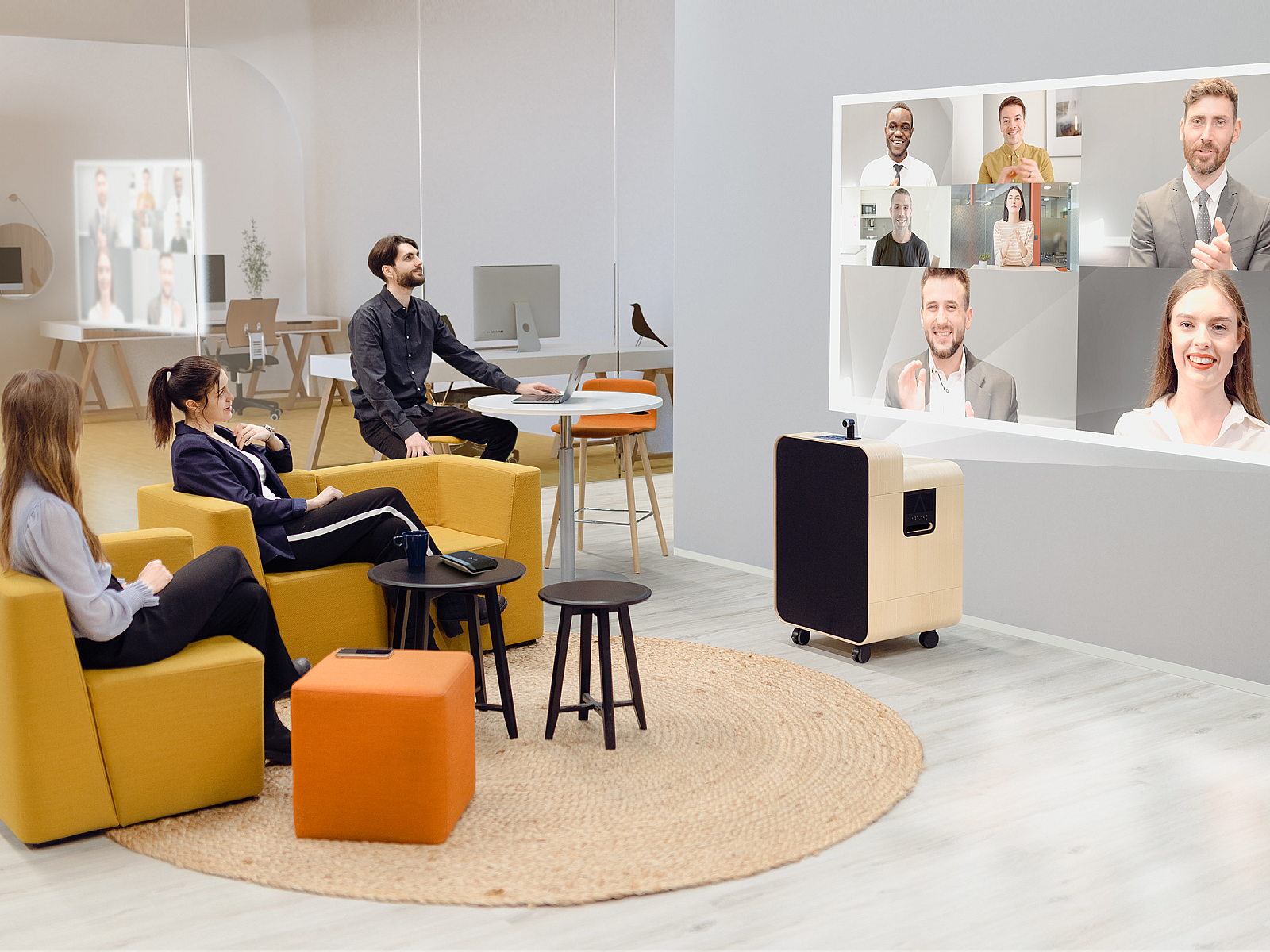 A group of employees sit in golden yellow chair facing a wall with the Artome M10 projecting a video conference call with multiple people.