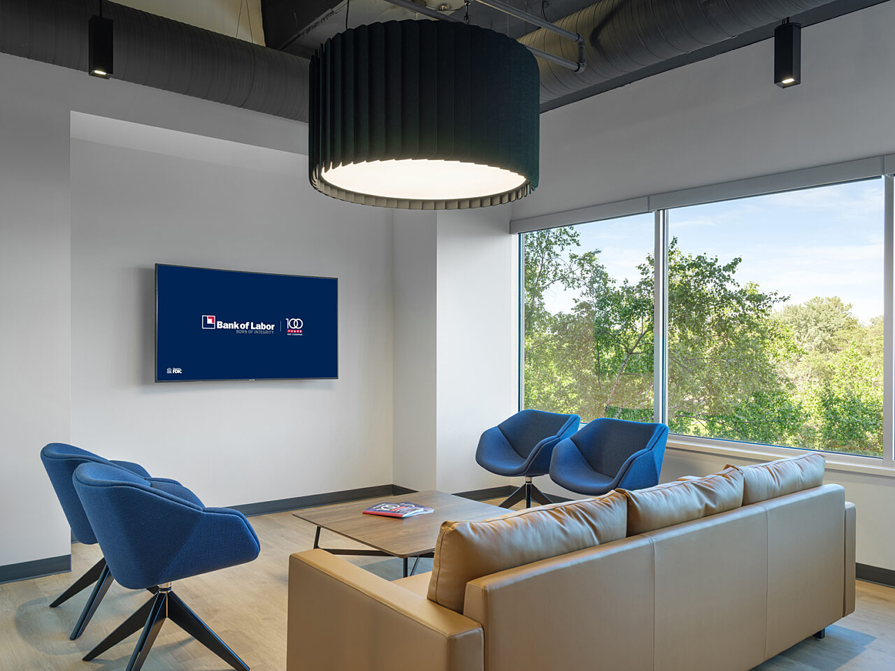 U-Shaped seating area with gold leather sofa and four blue mid-back lounge chairs with 4-prong wooden legs around square coffee table.