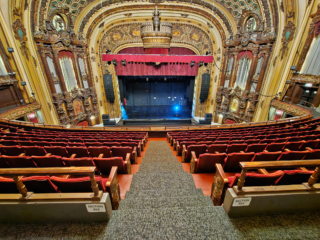 Kansas City's Midland Theatre - View of stage from upper, center seats - red upholstered seats with ornate details, ornate embellishments around stage