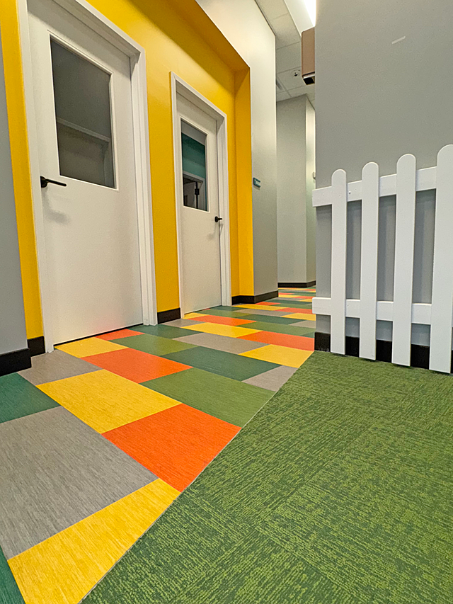 Riley ABA: A colorful, multicolored tile "deck" (yellow, orange, green, grey) shows the transition between the facility's main area & the child-sized town